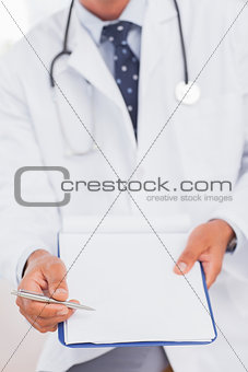 Doctor holding and presenting his clipboard and pen