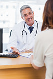 Happy doctor talking with his patient