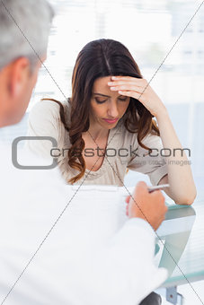 Sad woman listening to her docter talking about a illness