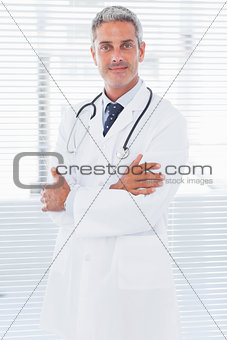 Happy doctor crossing his arms