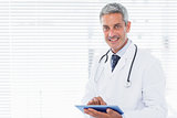 Smiling doctor using tablet pc