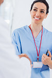 Happy nurse shaking hands with doctor