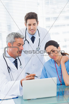 Nurse and doctors working together on a laptop