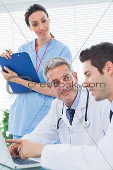 Nurse listening to doctors talking about something on their laptop