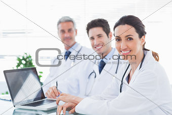 Doctors with laptop smiling at camera