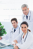 Team of doctors working together looking at camera