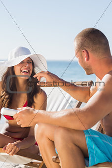 Attractive man applying sun cream on his girlfriends nose