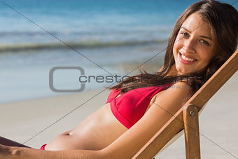 Smiling pretty woman relaxing on her deck chair
