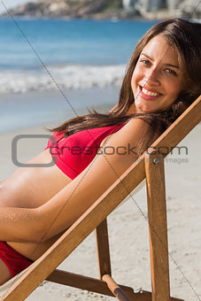 Cheerful pretty woman relaxing on her deck chair