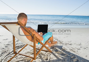 Relaxed handsome man working on his laptop