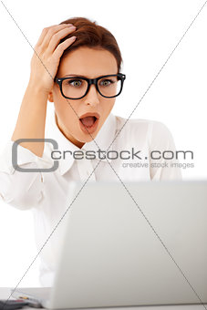 Woman looking at her laptop in horror