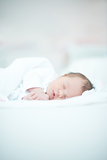 Newborn Baby Laying on White Bed