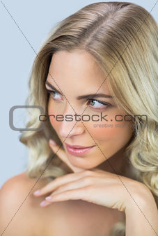Pensive natural blond model posing touching her face