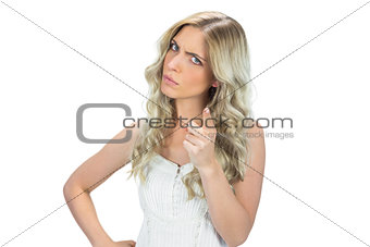 Frowning model in white dress pointing at camera