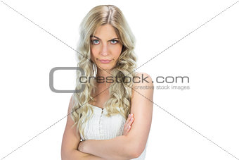 Doubtful model in white dress rising her eyebrow