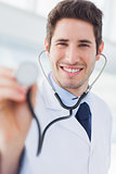 Happy doctor with his stethoscope looking at camera