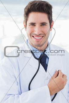 Cheerful doctor with his stethoscope looking at camera