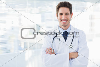 Smiling doctor crossed his arms and looking at camera