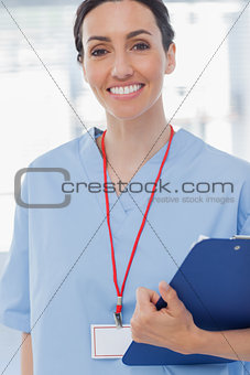 Smiling nurse holding files and looking at camera