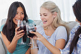 Happy friends toasting with red wine together