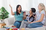 Cheerful friends having red wine together and talking