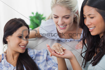 Friends admiring brunettes engagement ring