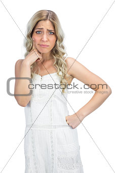Doubtful curly haired blonde having interrogative posture