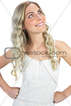 Smiling sexy blonde hands on hips looking up