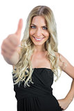Smiling gorgeous blonde in black dress thumbs up