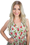 Happy blonde wearing flowered dress posing