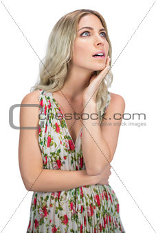 Pensive pretty blonde wearing flowered dress posing