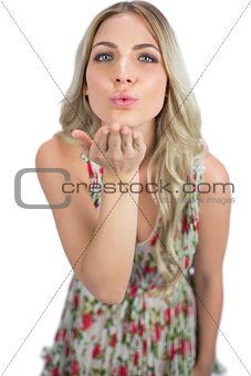 Seductive blonde wearing flowered dress sending a kiss