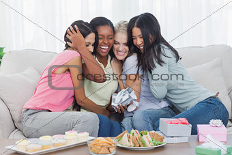 Friends offering gifts and hugging woman during party