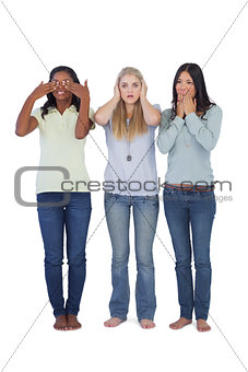Young women acting out three wise monkeys