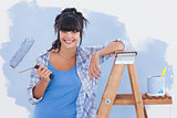 Woman holding paint roller leaning on ladder