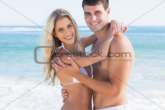 Gorgeous couple hugging and smiling at camera