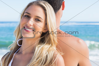 Blonde smiling and leaning against her boyfriend