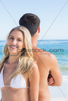 Happy blonde smiling and leaning against her boyfriend