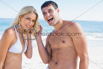 Happy couple listening to seashell