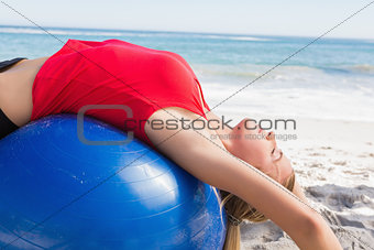Fit blonde stretching back on exercise ball