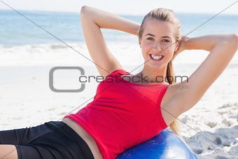 Fit blonde doing sit ups on exercise ball