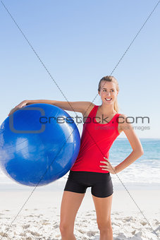 Fit blonde woman holding exercise ball