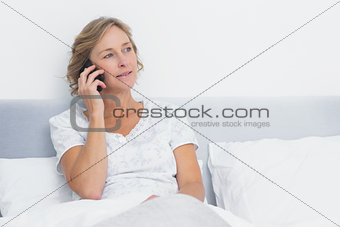 Blonde woman on the phone in bed