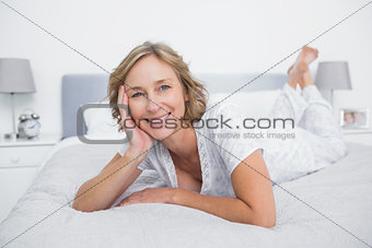 Content blonde woman lying on bed