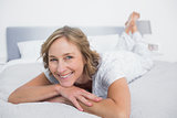 Happy blonde woman lying on bed