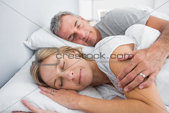 Couple sleeping and spooning in bed