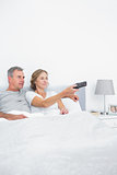 Content couple watching tv in bed