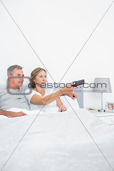 Content couple watching tv in bed