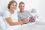 Happy couple using their tablet pc to buy online