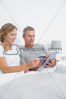 Relaxed couple using their tablet pc to buy online